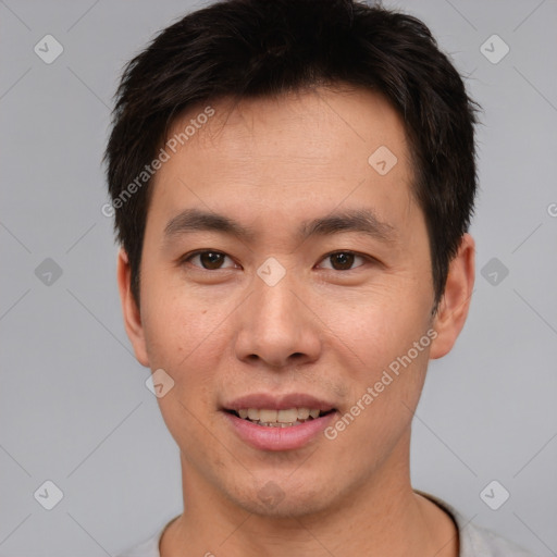 Joyful asian young-adult male with short  brown hair and brown eyes