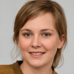 Joyful white young-adult female with medium  brown hair and green eyes