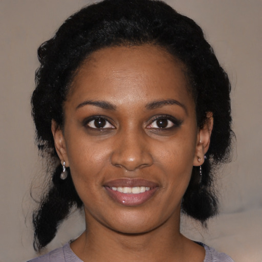Joyful black young-adult female with medium  black hair and brown eyes