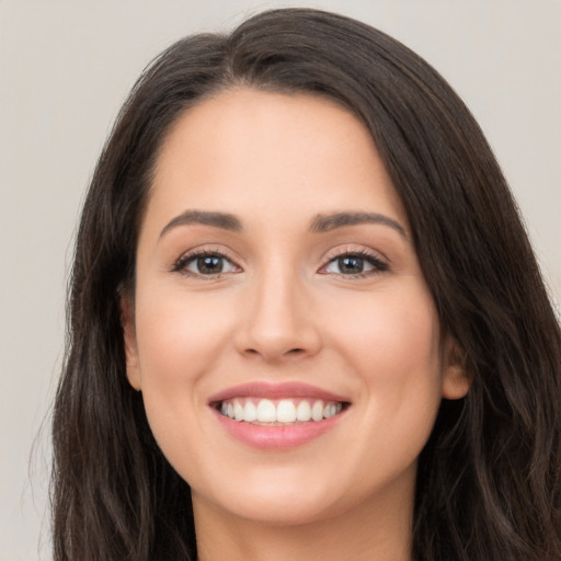 Joyful white young-adult female with long  brown hair and brown eyes