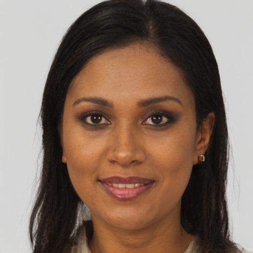 Joyful black young-adult female with long  brown hair and brown eyes