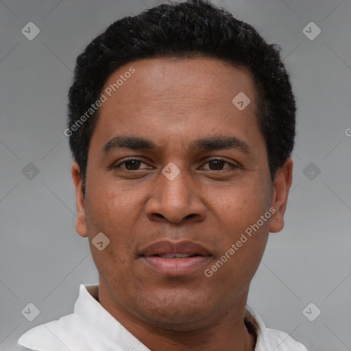 Joyful black adult male with short  black hair and brown eyes