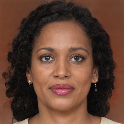 Joyful black adult female with long  brown hair and brown eyes