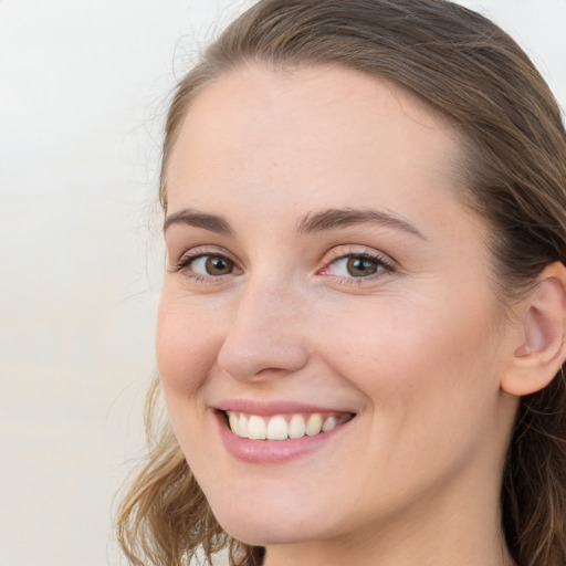 Joyful white young-adult female with long  brown hair and grey eyes