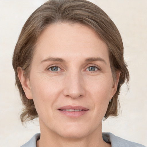 Joyful white adult female with medium  brown hair and grey eyes