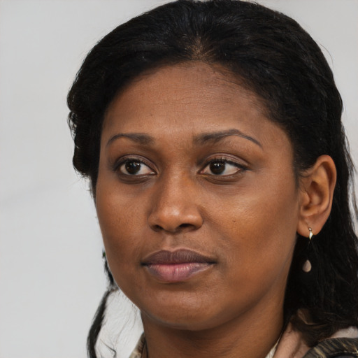 Joyful black young-adult female with long  brown hair and brown eyes