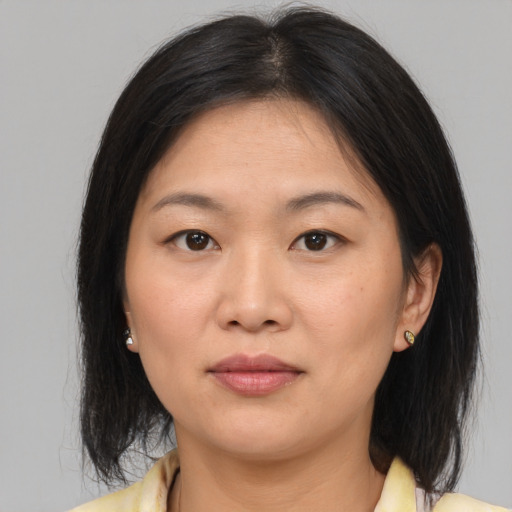 Joyful asian young-adult female with medium  brown hair and brown eyes