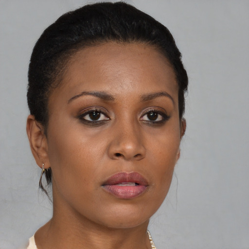 Joyful black young-adult female with long  brown hair and brown eyes