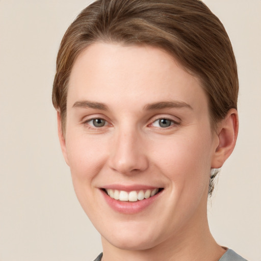 Joyful white young-adult female with short  brown hair and grey eyes