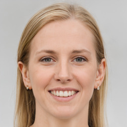 Joyful white young-adult female with long  brown hair and blue eyes