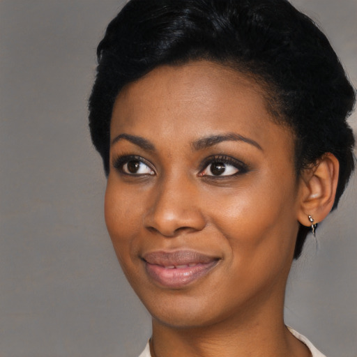 Joyful black young-adult female with short  black hair and brown eyes