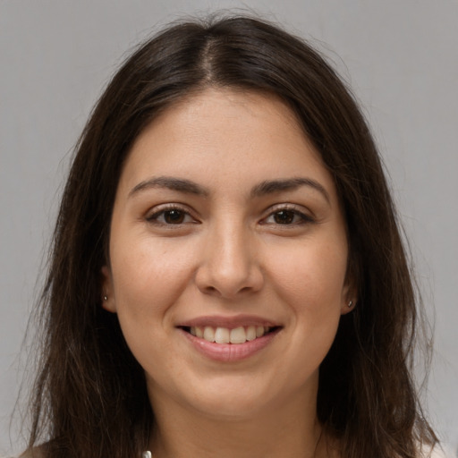 Joyful white young-adult female with long  brown hair and brown eyes