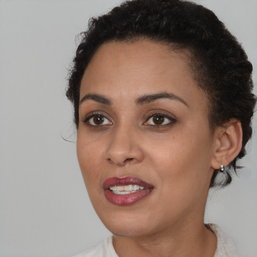 Joyful black young-adult female with short  brown hair and brown eyes