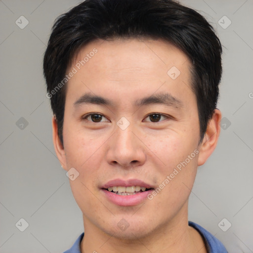 Joyful asian young-adult male with short  brown hair and brown eyes