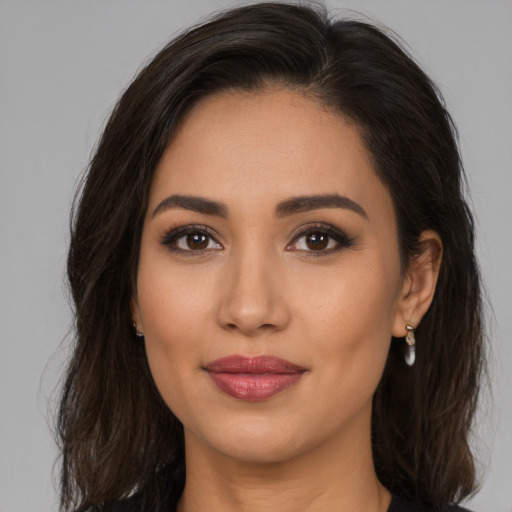 Joyful latino young-adult female with medium  brown hair and brown eyes