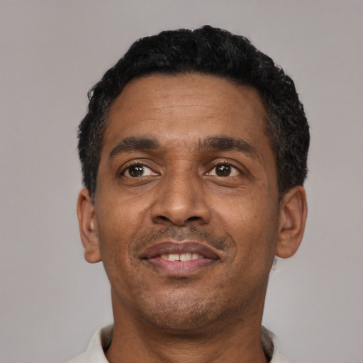 Joyful latino adult male with short  black hair and brown eyes