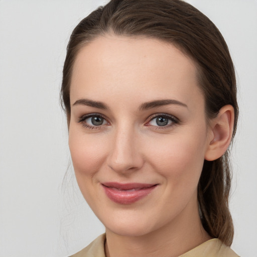 Joyful white young-adult female with medium  brown hair and grey eyes