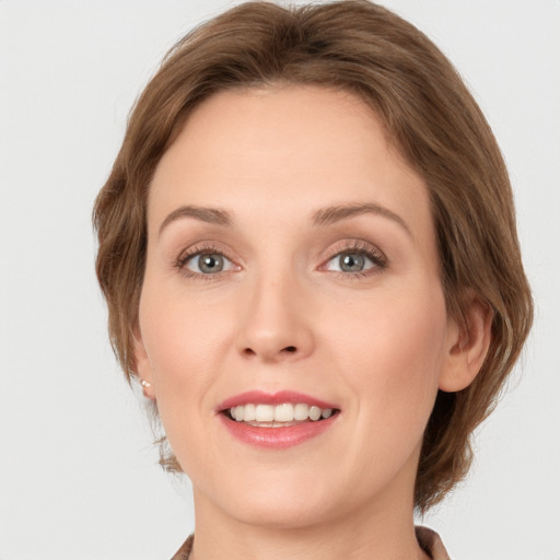 Joyful white young-adult female with medium  brown hair and green eyes