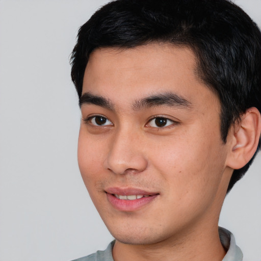 Joyful asian young-adult male with short  black hair and brown eyes