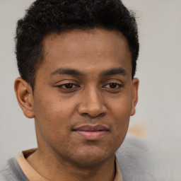 Joyful latino young-adult male with short  brown hair and brown eyes