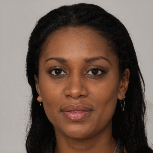 Joyful black young-adult female with long  black hair and brown eyes