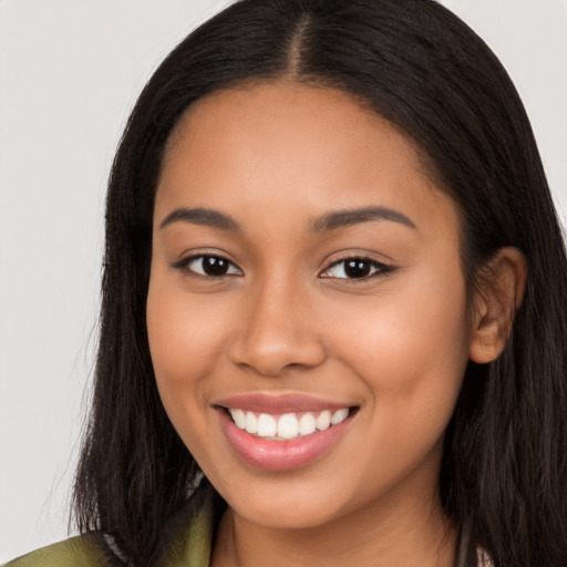 Joyful latino young-adult female with long  brown hair and brown eyes