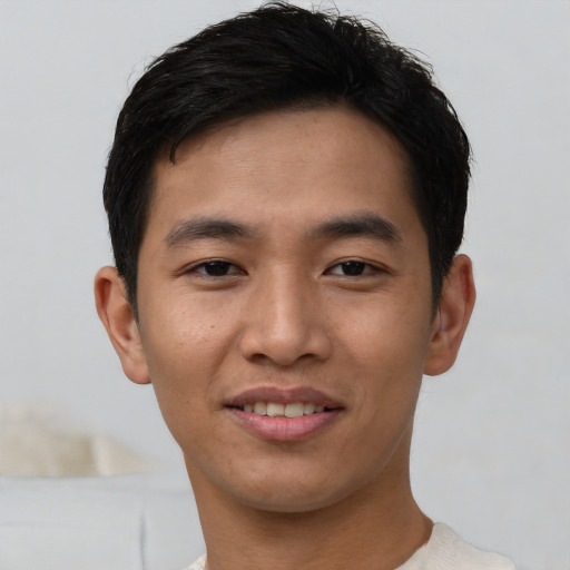 Joyful asian young-adult male with short  brown hair and brown eyes