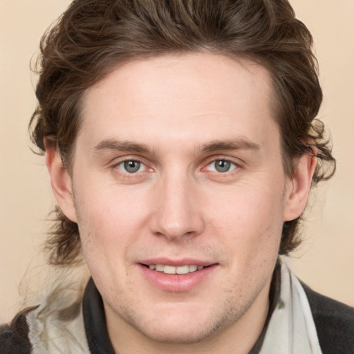 Joyful white young-adult male with medium  brown hair and grey eyes