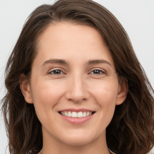 Joyful white young-adult female with long  brown hair and brown eyes