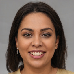 Joyful latino young-adult female with medium  brown hair and brown eyes