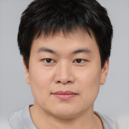 Joyful asian young-adult male with short  brown hair and brown eyes