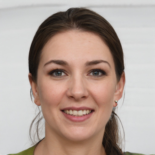 Joyful white young-adult female with medium  brown hair and grey eyes