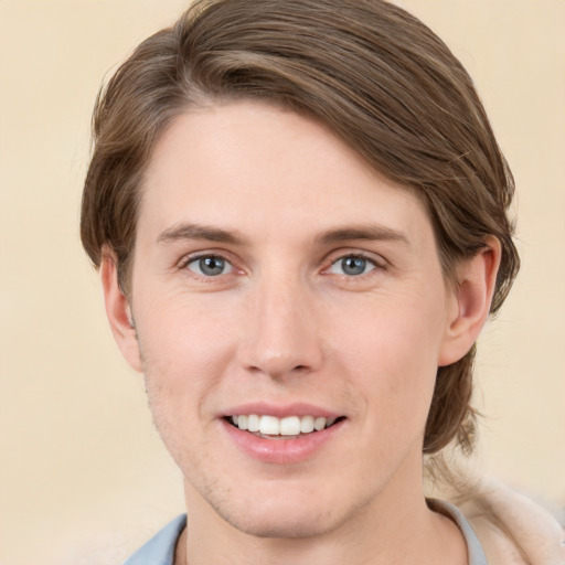 Joyful white young-adult male with medium  brown hair and grey eyes