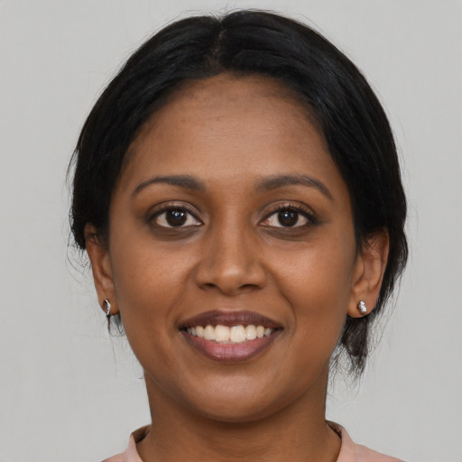 Joyful black young-adult female with medium  black hair and brown eyes