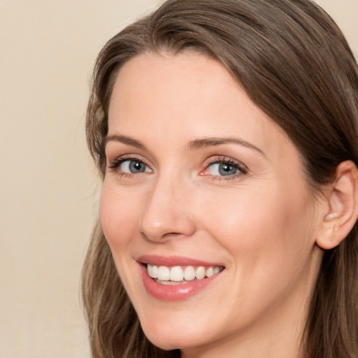 Joyful white young-adult female with long  brown hair and grey eyes