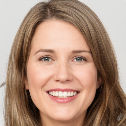 Joyful white young-adult female with long  brown hair and brown eyes