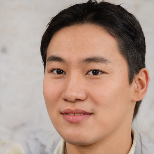 Joyful asian young-adult male with short  brown hair and brown eyes