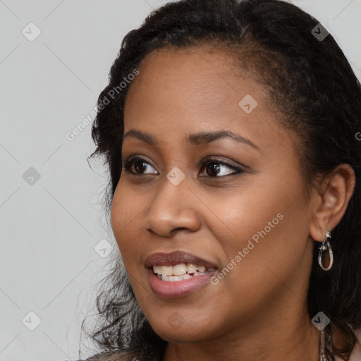 Joyful black young-adult female with long  brown hair and brown eyes