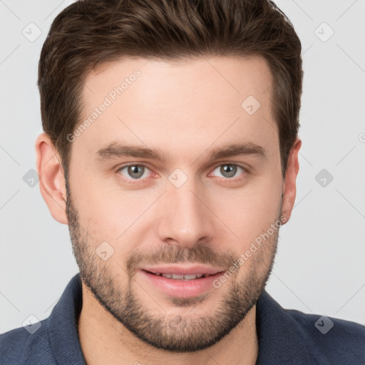 Joyful white young-adult male with short  brown hair and grey eyes