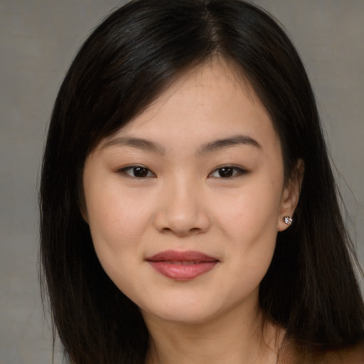 Joyful asian young-adult female with long  brown hair and brown eyes
