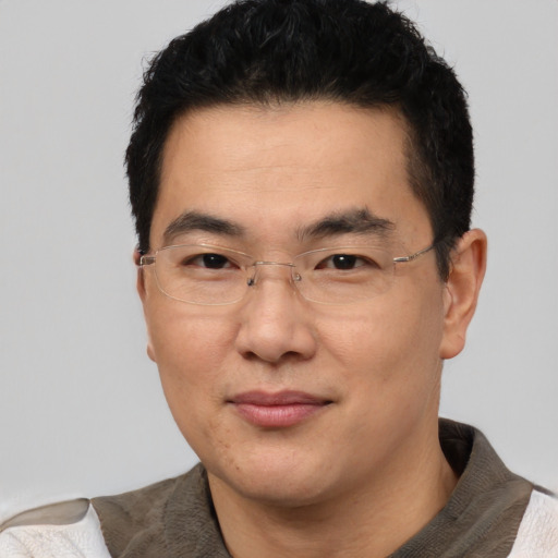 Joyful asian adult male with short  black hair and brown eyes