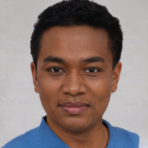 Joyful black young-adult male with short  black hair and brown eyes