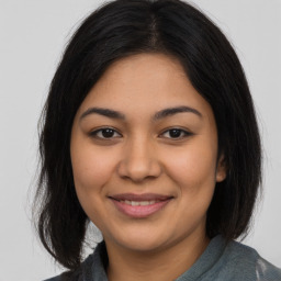 Joyful latino young-adult female with medium  brown hair and brown eyes