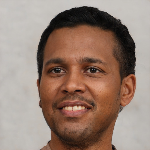 Joyful black young-adult male with short  black hair and brown eyes