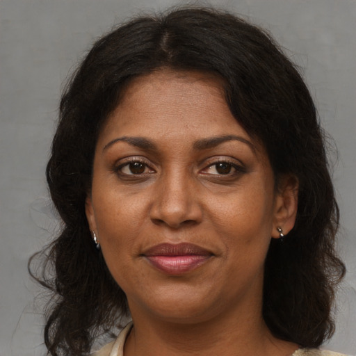 Joyful black adult female with medium  brown hair and brown eyes