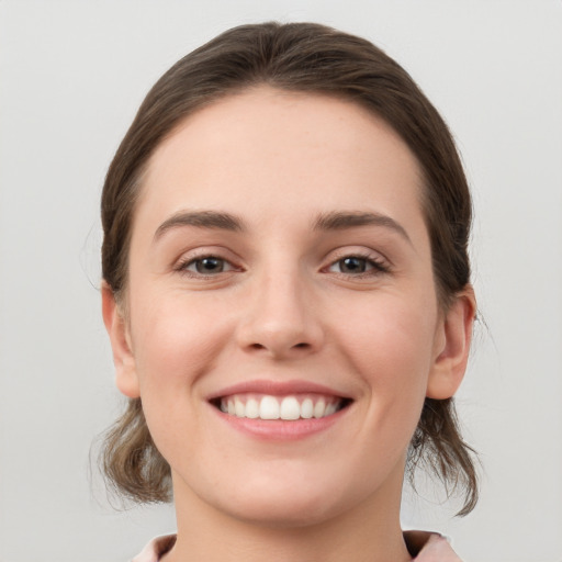 Joyful white young-adult female with medium  brown hair and grey eyes