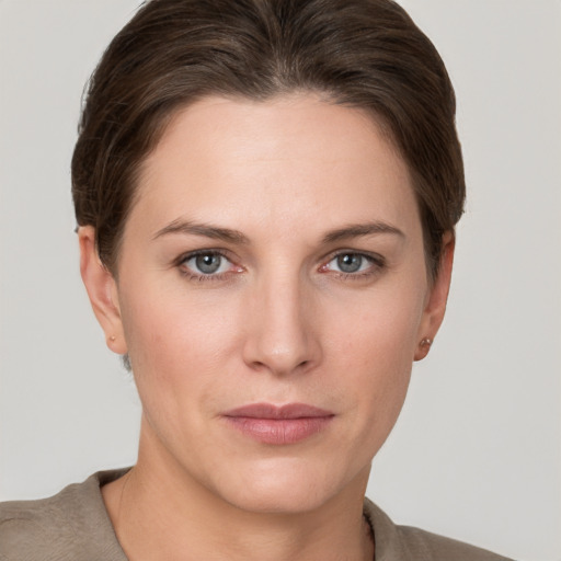 Joyful white young-adult female with short  brown hair and grey eyes