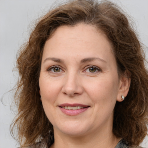 Joyful white adult female with medium  brown hair and brown eyes