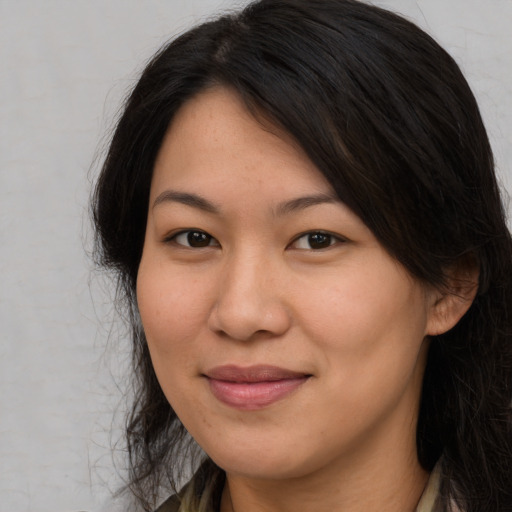 Joyful asian young-adult female with long  brown hair and brown eyes