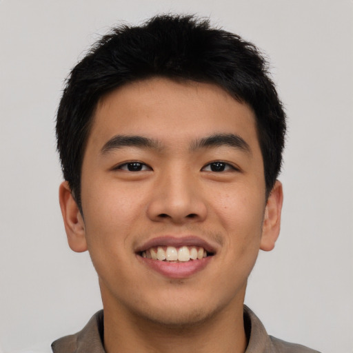 Joyful asian young-adult male with short  brown hair and brown eyes